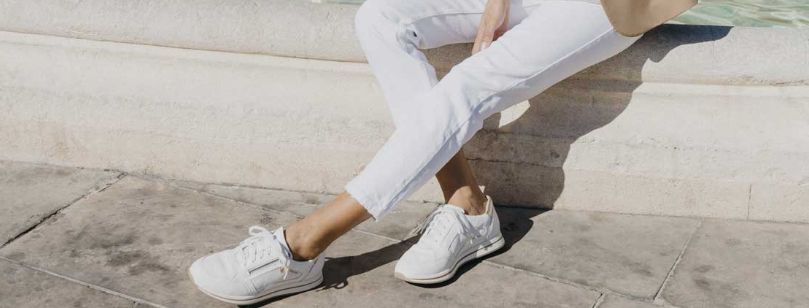 Vrouw zittend op fontein met Mephisto schoenen aan